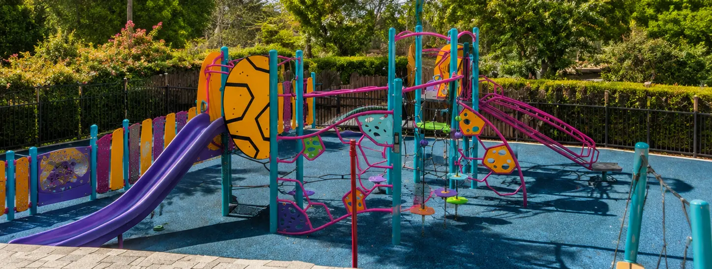 Creekside’s colorful outdoor climbing structure, slide, balance elements, and open play area